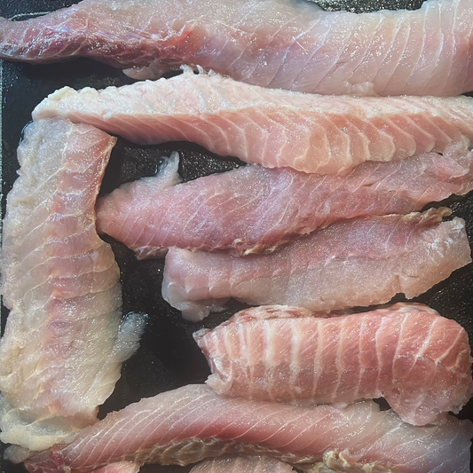 Raw fish fillets on a dark surface